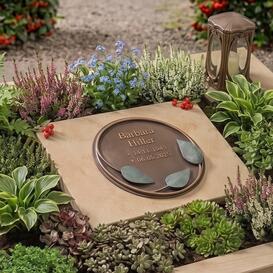 Urnengrabstein liegend in hellem Kalkstein mit Bronze...